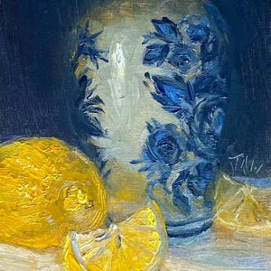 May include: A still life painting of a blue and white ceramic vase with floral designs, two yellow lemons, and a lemon slice on a light brown surface.
