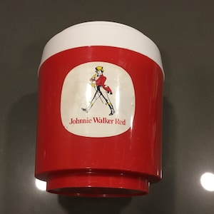 May include: Red and white plastic cooler with a Johnnie Walker Red label featuring a man in a red coat walking with a stick.