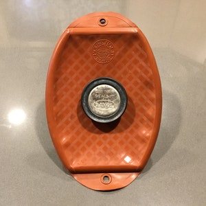 May include: Orange rubber jar lid sealer with a black and silver "One Turn Seal-It" jar lid with the word "Davo" printed on it.
