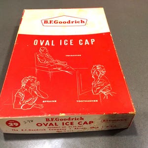 May include: A red and white box with the text "B.F. Goodrich Oval Ice Cap" on the front. The box has illustrations of people using the ice cap for headaches, sprains, and toothaches. The box is labeled "No. 29" and has the text "The B.F. Goodrich Company Akron, Ohio U.S.A."