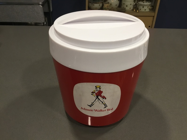 May include: A red and white cooler with a white lid and a Johnnie Walker Red label featuring a man in a red coat and a top hat walking with a cane.