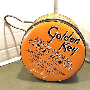 May include: Vintage Golden Key moth crystal closet hanger. The orange and black container has a wire handle and features text that reads "Kills larvae and eggs" and "100% Paradichlorobenzene".