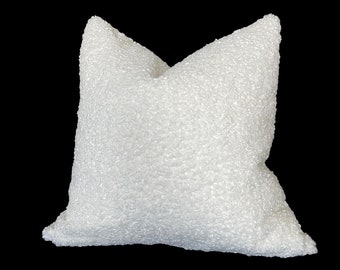 May include: A white, fluffy pillow with a textured surface. The pillow is made of a soft, plush material.