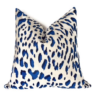 Puede incluir: Una almohada de tiro de estampado de leopardo azul y blanco. La almohada est&aacute; hecha de una tela suave y c&oacute;moda y tiene un brillo sutil.