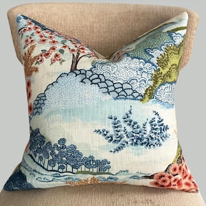 May include: A decorative pillow with a blue and green floral pattern on a white background. The pattern features trees, flowers, and leaves.