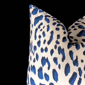 Puede incluir: Una almohada blanca con un estampado de leopardo azul.