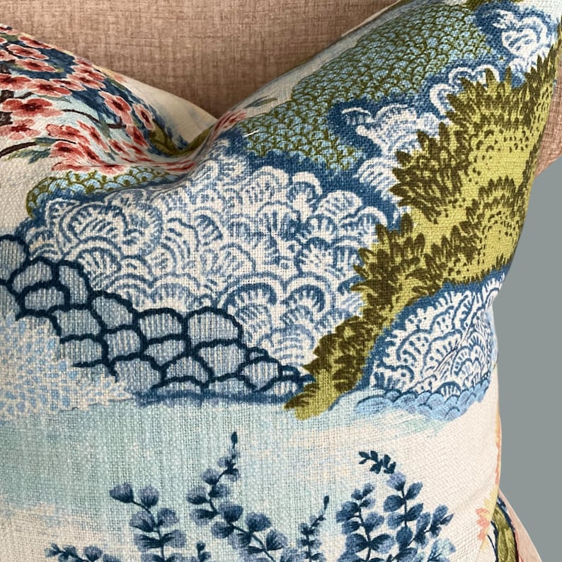May include: A blue and green patterned throw pillow with a floral design. The pillow features a light blue background with a repeating pattern of blue and green leaves and flowers.