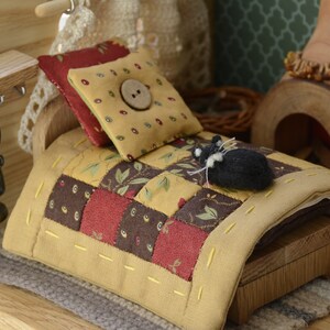 Può includere: Una camera da letto per bambole in miniatura con un letto di legno, una trapunta patchwork, un cuscino con un bottone e un piccolo animaletto di peluche nero e bianco.