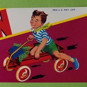 May include: A vintage label for Red Wagon brand fruit, featuring a red wagon with a boy riding it and a bunch of grapes in the wagon. The label is on a pink background with yellow and white accents. The text on the label reads "United States of America", "Red Wagon", "Royal Valley Fruit Growers Ass'n.", "Reedley, California", and "Reg. U.S. Pat. Off."