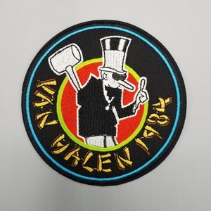 May include: Embroidered patch featuring a cartoon figure in a top hat, holding a mallet and giving a thumbs up. The patch has a black background with the words "VAN HALEN 84" in gold lettering, and a red and green circle.