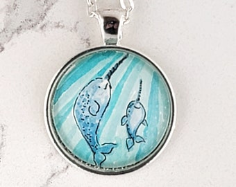 Narwhal necklace, mother and baby narwhal swimming in the light, watercolor hand-painted miniature illustration. Cute narwhals pendant