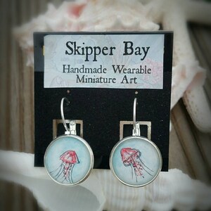 Jellyfish earrings hand-painted in watercolor. Pink jellyfish and teal or blue water, silver-plated earrings.