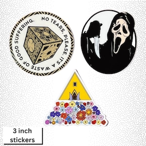 May include: Three 3-inch diameter stickers. One sticker features a yellow triangle with a house on top and a bed of flowers at the bottom. Another sticker features a black and white illustration of a masked figure holding a knife. The third sticker features a black and white illustration of a cube with the text "It's a waste of good suffering. No tears, please."