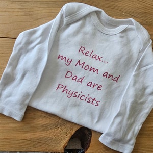 May include: White long-sleeve baby onesie with pink text that reads "Relax... my Mom and Dad are Physicists".