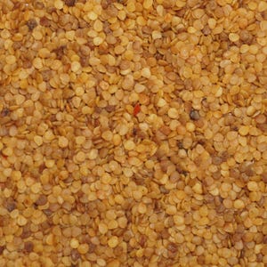 May include: A close-up view of a pile of small, light brown peppercorns.
