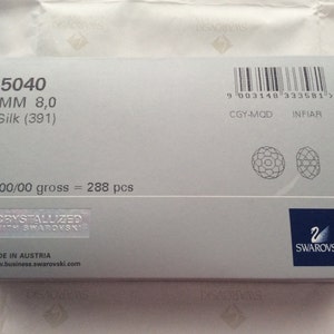 Pu&ograve; includere: Una scatola bianca con un codice a barre, informazioni sul prodotto e il logo Swarovski. La scatola contiene 288 pezzi di cristalli Silk (391) da 8,0 mm.