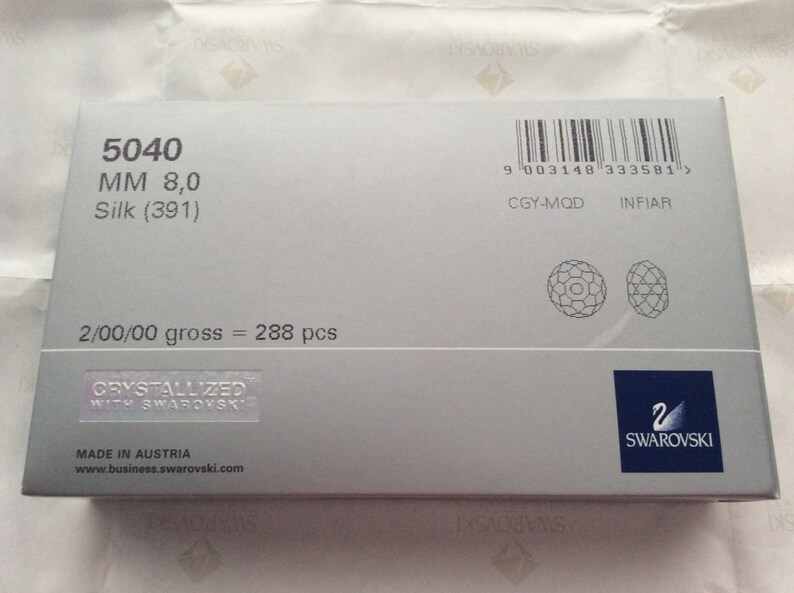 Pu&ograve; includere: Una scatola bianca con un codice a barre, informazioni sul prodotto e il logo Swarovski. La scatola contiene 288 pezzi di cristalli Silk (391) da 8,0 mm.