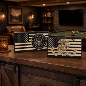 May include: Two rectangular wooden signs featuring black and natural wood stripes and stars. The left sign displays the United States Army seal, while the right sign features the United States Marine Corps emblem with the text United States Marine Corps.