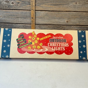 May include: A rectangular cardboard box for Universal decorative outdoor Christmas lights. The box features a cream center with a red scalloped graphic, a yellow Christmas tree illustration, and the text Each Lamp Burns Independently.