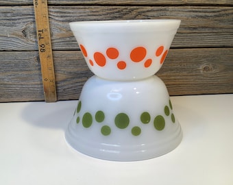 May include: Two white mixing bowls with a retro design. The top bowl has orange polka dots and the bottom bowl has green polka dots.