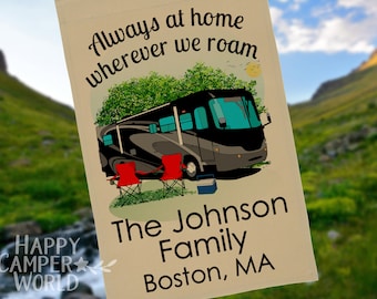 May include: A tan-colored fabric garden flag with a black RV, two red folding chairs, and a blue cooler. The text on the flag reads "Always at home wherever we roam The Johnson Family Boston, MA".