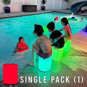 May include: A group of children are enjoying a pool party with inflatable chairs. The chairs are glowing in different colors, creating a fun and festive atmosphere. The chairs are made of durable, waterproof material and are perfect for poolside lounging.