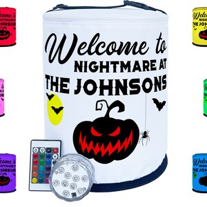 May include: White Halloween-themed cooler with the text "Welcome to Nightmare at The Johnsons" and a black pumpkin with red eyes and a menacing grin. The cooler has a blue trim and is surrounded by six smaller coolers in various colors with the same design.