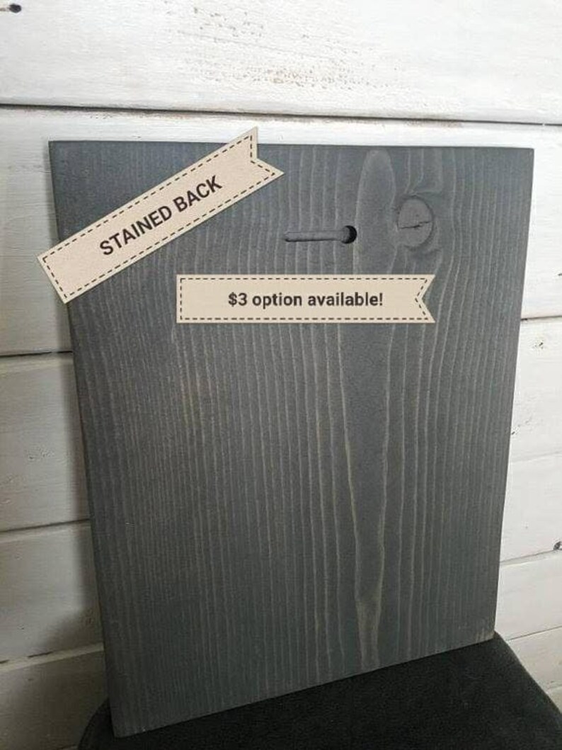 May include: The back of a wooden sign with a stained gray finish. The sign has a hole in the top for hanging. A label reads "$3 option available!"