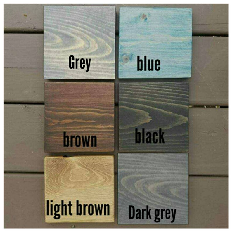 May include: Five wood samples stained in different colors: grey, blue, brown, black, and dark grey. The wood samples are labeled with their respective colors.
