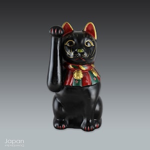 black maneki neko with red and green striped bib, clay beckoning cat