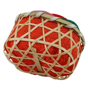 May include: A small, orange, woven basket with a bamboo frame. The basket is lined with a red, green, and pink fabric.