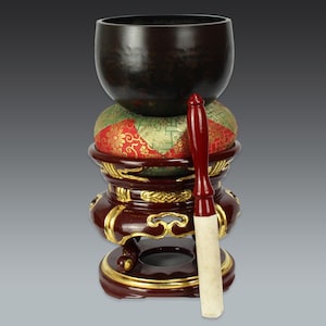 handcrafted small buddhist temple singing bowl on brocade cushion and red lacquer stand