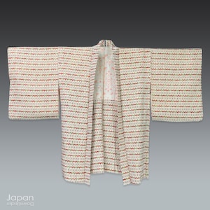 Peut inclure: Un kimono japonais blanc avec un motif géométrique dans des tons de rouge, vert et marron. Le kimono a une doublure florale rose et blanche.