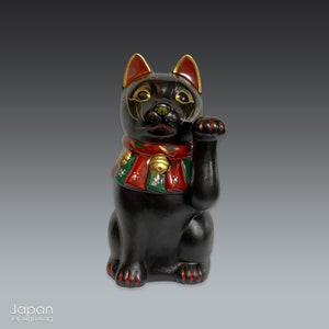 black maneki neko with red and green striped bib, clay beckoning cat