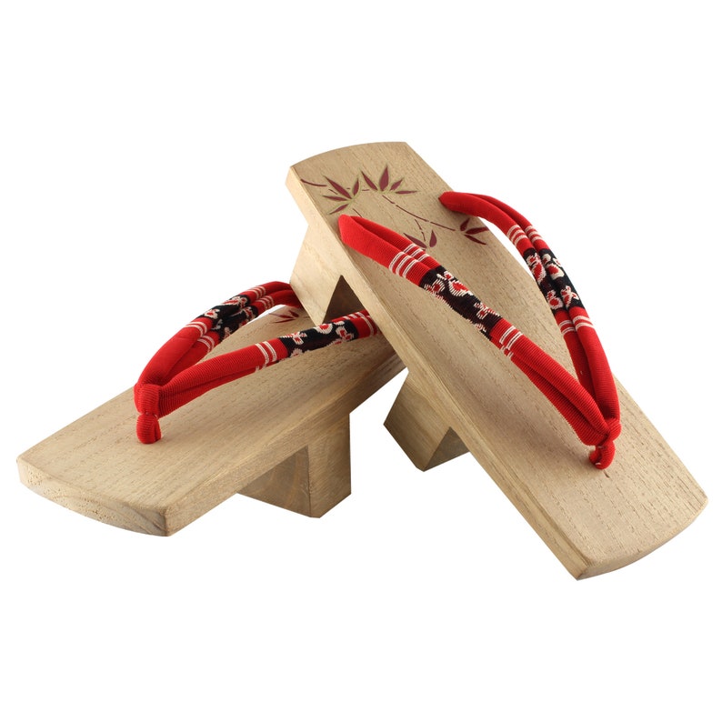May include: A pair of wooden geta sandals with red and black fabric straps. The sandals have a traditional Japanese design.