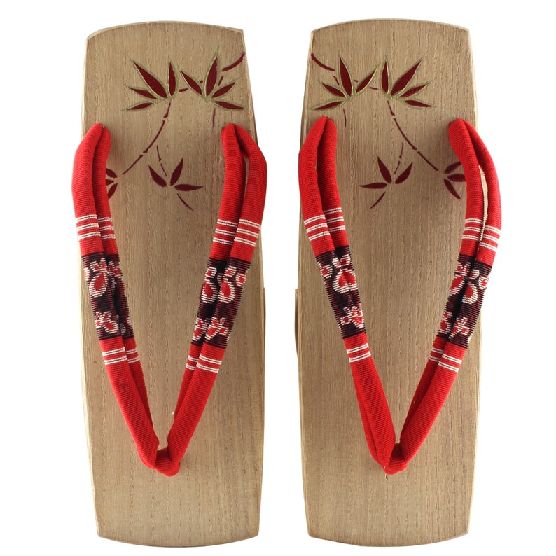 May include: A pair of traditional Japanese wooden sandals, known as geta, with red and white fabric straps. The sandals have a simple design with a leaf pattern on the wooden base.