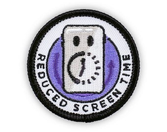 May include: A round, embroidered patch with the words "REDUCED SCREEN TIME" in white text on a black border. The center features a white smartphone with a clock graphic inside a purple circle.