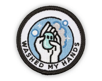May include: A white and blue embroidered patch with a hand holding a bar of soap and bubbles. The text "WASHED MY HANDS" is written around the edge of the patch.