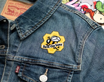 May include: A denim jacket with a yellow and black bee patch that says "Save the bees".