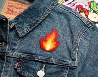 May include: A red and yellow embroidered flame patch on a blue denim jacket.
