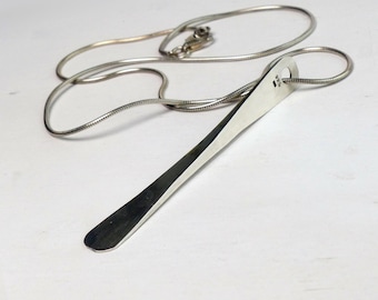 May include: A silver-colored metal pendant shaped like a miniature shoehorn, suspended from a thin snake chain necklace. The pendant features a small hole at the top for the chain and is stamped with the hallmark 925, indicating sterling silver.