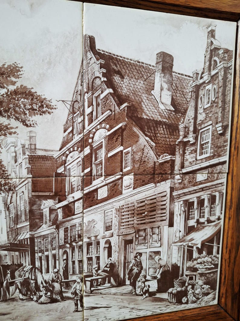 May include: A sepia-toned tile set depicting a European town scene. The artwork shows buildings, people, and a horse-drawn carriage. The tiles are framed in a dark wood.
