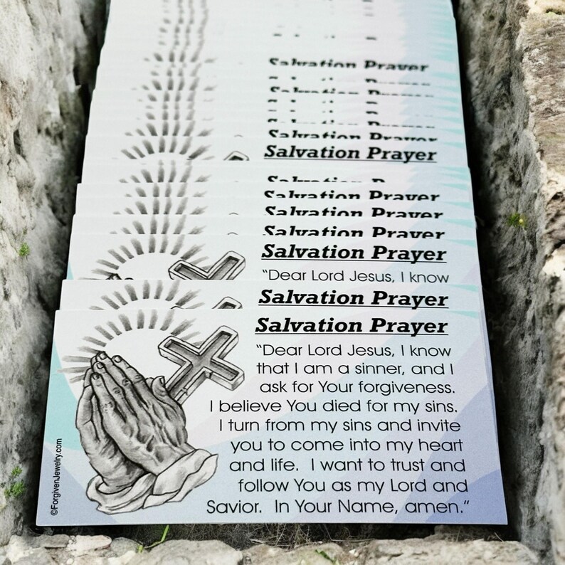 May include: A stack of white cards with the text "Salvation Prayer" printed on them. The top card has a drawing of praying hands and a cross. The text on the top card reads "Dear Lord Jesus, I know that I am a sinner, and I ask for Your forgiveness. I believe You died for my sins. I turn from my sins and invite you to come into my heart and life. I want to trust and follow You as my Lord and Savior. In Your Name, amen."