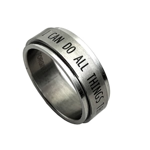 May include: A silver spinning ring with the words "I can do all things through Christ who strengthens me" engraved on the band.