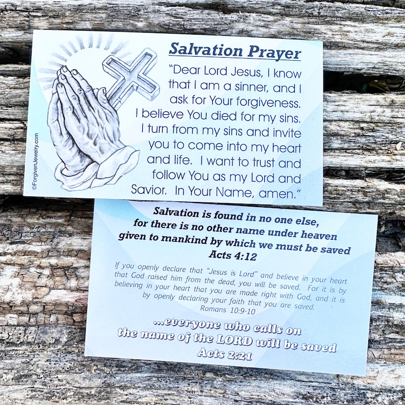 May include: Two blue and white cards with a Christian prayer for salvation. The top card features a drawing of hands in prayer with a cross. The text on the card reads "Salvation Prayer" and includes a prayer to Jesus. The bottom card features the text "Salvation is found in no one else..." and includes bible verses from Acts 4:12, Romans 10:9-10, and Acts 2:21.