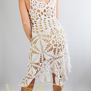 May include: White crochet dress with a delicate floral pattern. The dress has a loose fit and a flowing skirt. The dress is made of a lightweight, breathable fabric. The dress is perfect for a summer day or a special occasion.