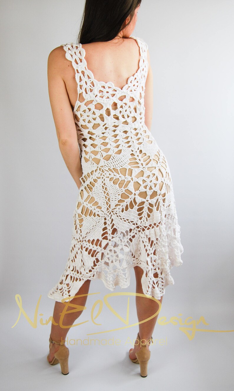 May include: White crochet dress with a delicate floral pattern. The dress has a loose fit and a flowing skirt. The dress is made of a lightweight, breathable fabric. The dress is perfect for a summer day or a special occasion.
