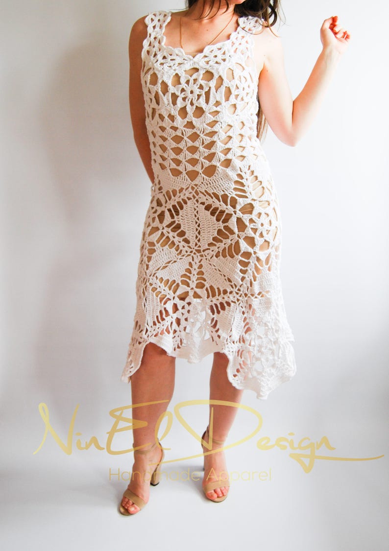 May include: White crochet dress with a delicate, lacy pattern. The dress has a sleeveless design and a flowing skirt.