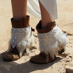 Handmade feather bridal shoe cuffs with ivory feathers, Swarovski crystal applique, and soft cotton trims. These boho wedding boot covers add sparkle and charm to bridal boots, sandals, or festival shoes. Adjustable buckle strap for comfort, unique boho accessory, perfect for brides, bridesmaids, or gifts
