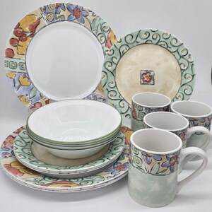 May include: A set of colorful floral patterned dinnerware, including plates, bowls, and mugs. The set features a green, yellow, and red floral design with a white background.